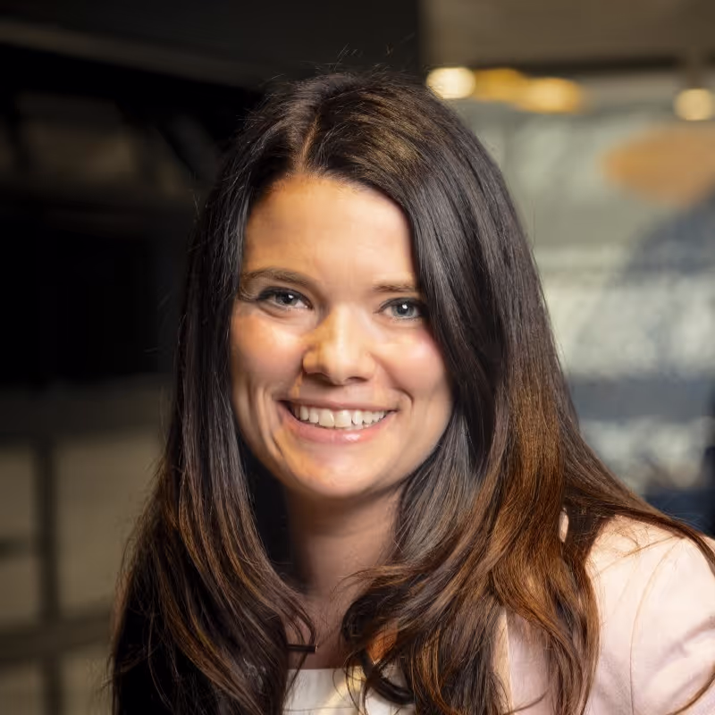 Smiling woman with long brown hair in professional office setting